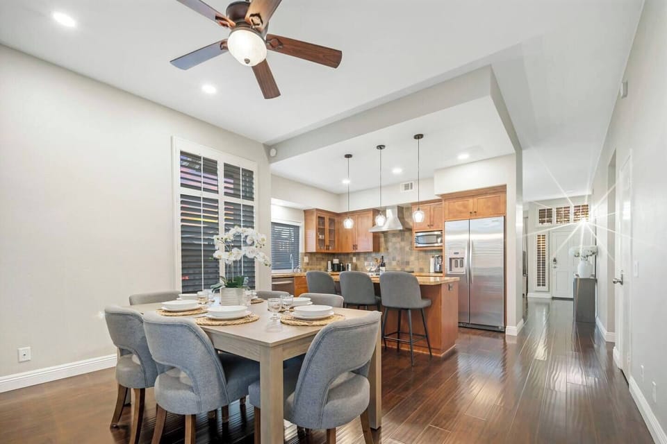 The dining room comfortably seats six and features a sliding door that opens to the backyard for easy outdoor access. A kitchen island with three barstools provides extra seating, making it ideal for both formal meals and casual gatherings.