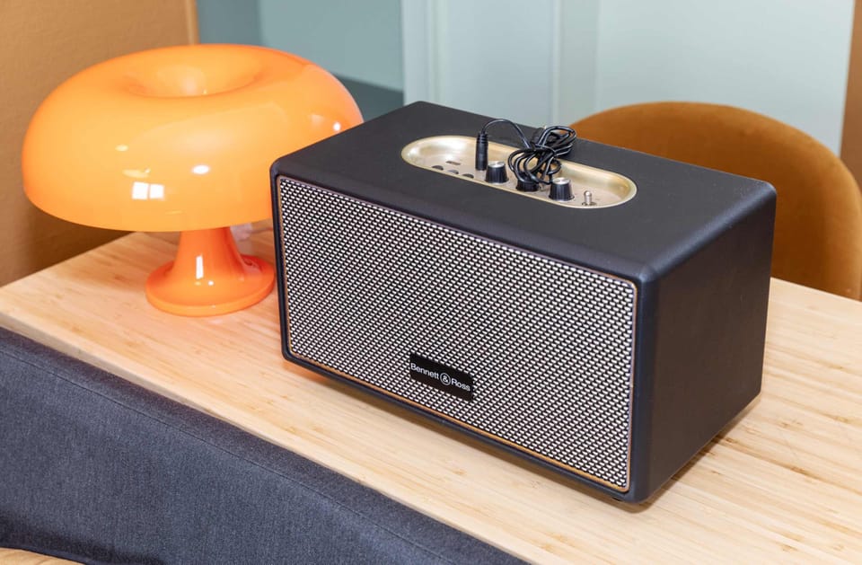 Modern bedside setup with ambient lighting and a Bluetooth speaker for a cozy and connected stay.