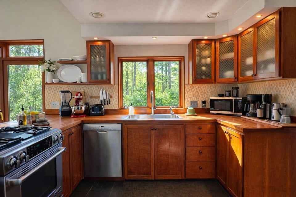 Sunlit, fully equipped kitchen with forest views and a coffee bar