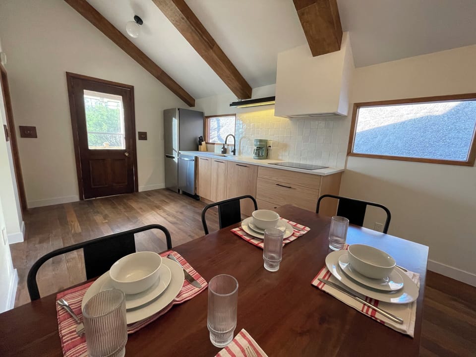 Gather around the dining table, set for memorable meals and cozy conversations in this stylish kitchen.