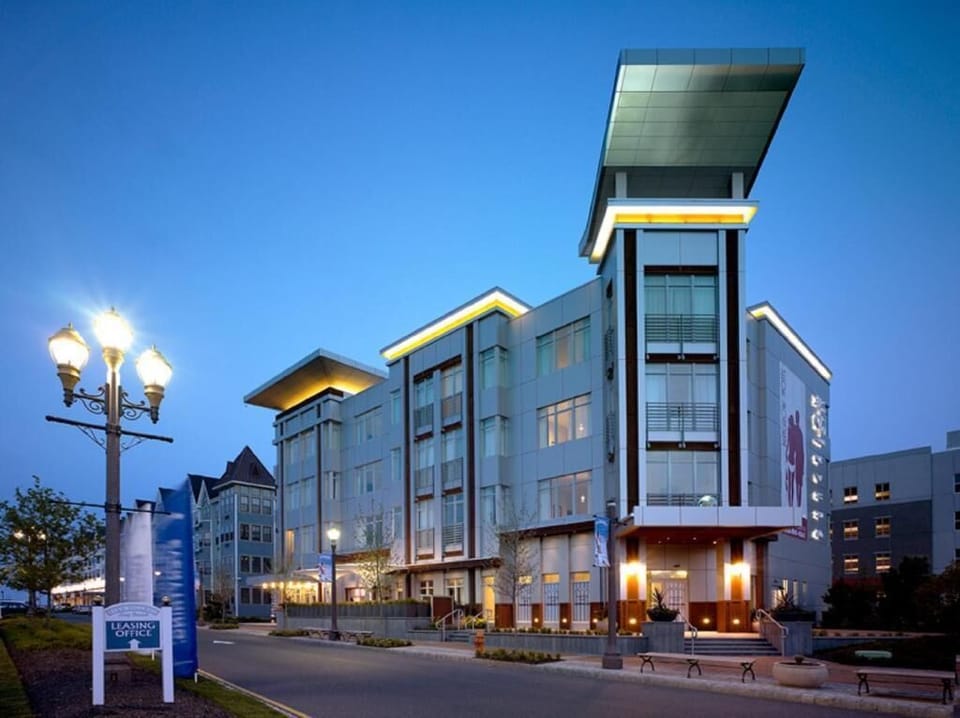 Step into a sleek stay as the building glows at dusk.