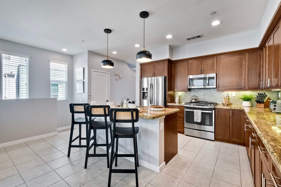 Island countertop with space for cooking preparation and seating for three (additional seating for three found behind couch)