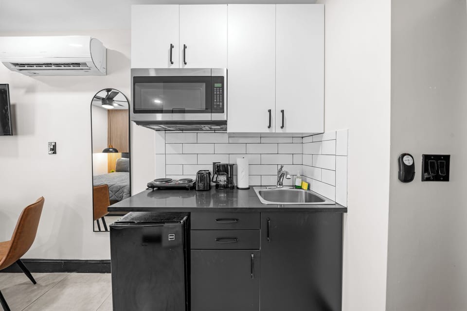 The kitchenette is compact but fully functional, featuring essentials like a microwave, stovetop, fridge, and coffee maker. Perfect for preparing simple meals during your stay.
