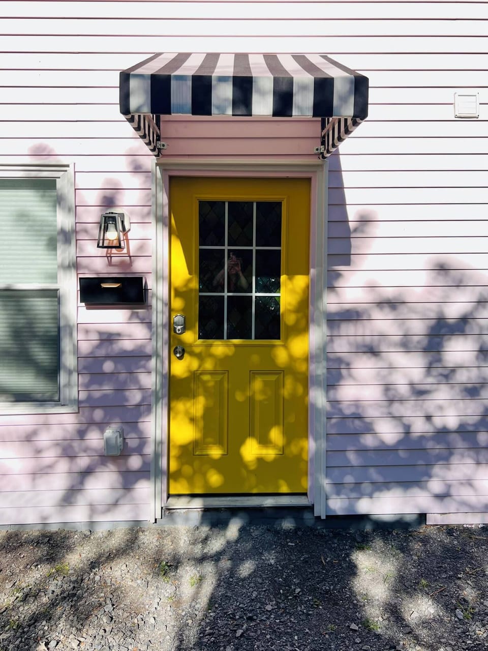 [Main Door] Bright yellow with a cozy roof and smart lock. Welcoming you home with a warm glow!