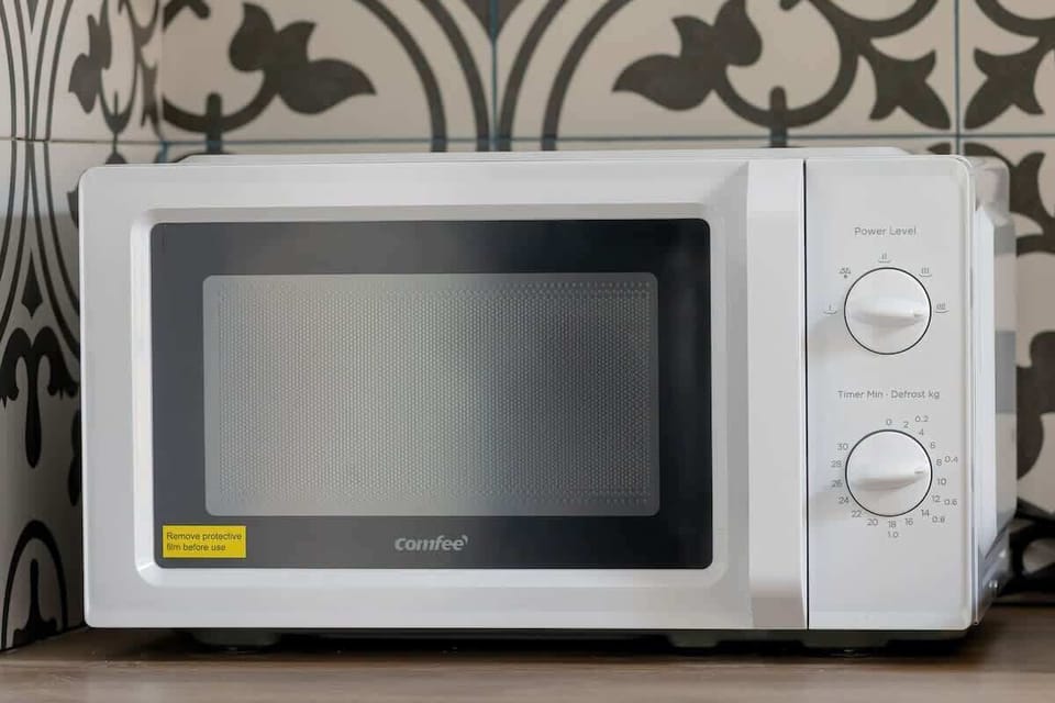 Close-up of the microwave area showing ornate wallpaper and a clean, well-kept kitchen detail.