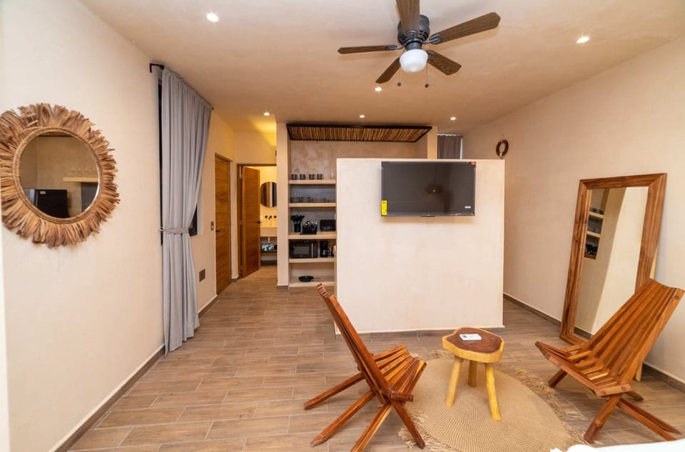 a bedroom with bed and chair in Tulum apartment accommodations