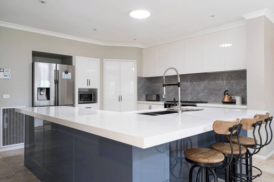 The kitchen is designed around a central island with a breakfast bar for slow mornings at home.
