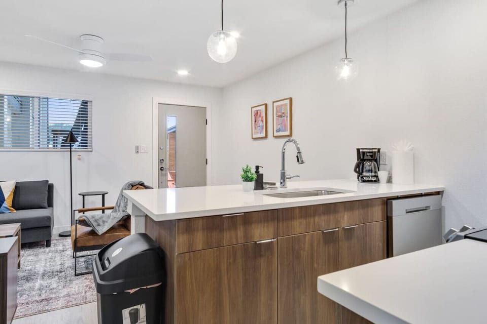 Prepare meals in this modern, fully-equipped kitchen featuring stainless steel appliances and a spacious island with bar seating. The open layout makes it easy to cook and entertain, ensuring a delightful culinary experience during your stay.