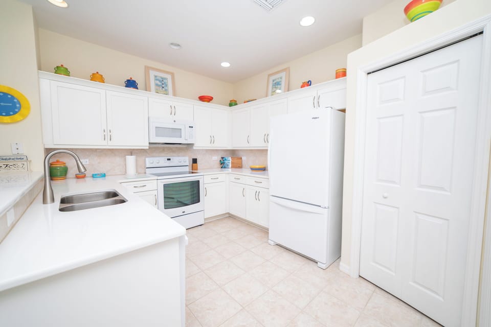 Fully equipped kitchen with white appliances.