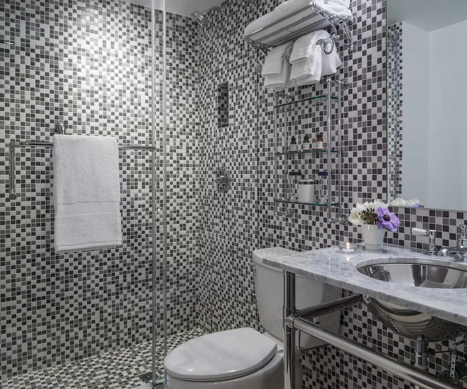 Refresh in a sparkling mosaic shower with fluffy towels ready.