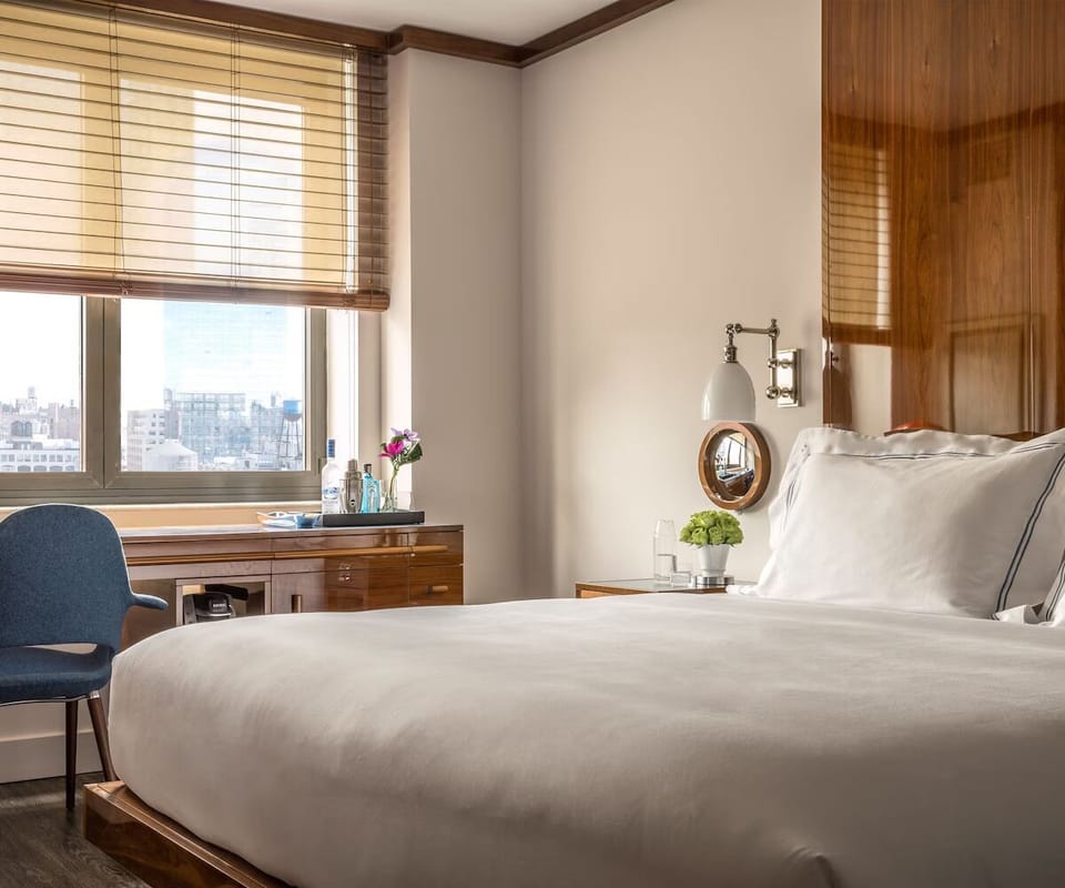 Sink into plush bedding with bright city views ahead.