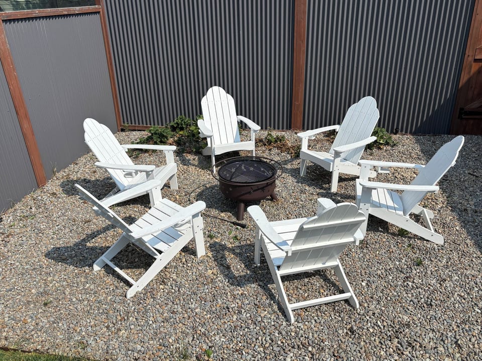 Gather 'round the fire pit — six Adirondack chairs in the fenced backyard, one for every guest. S'mores strongly encouraged.