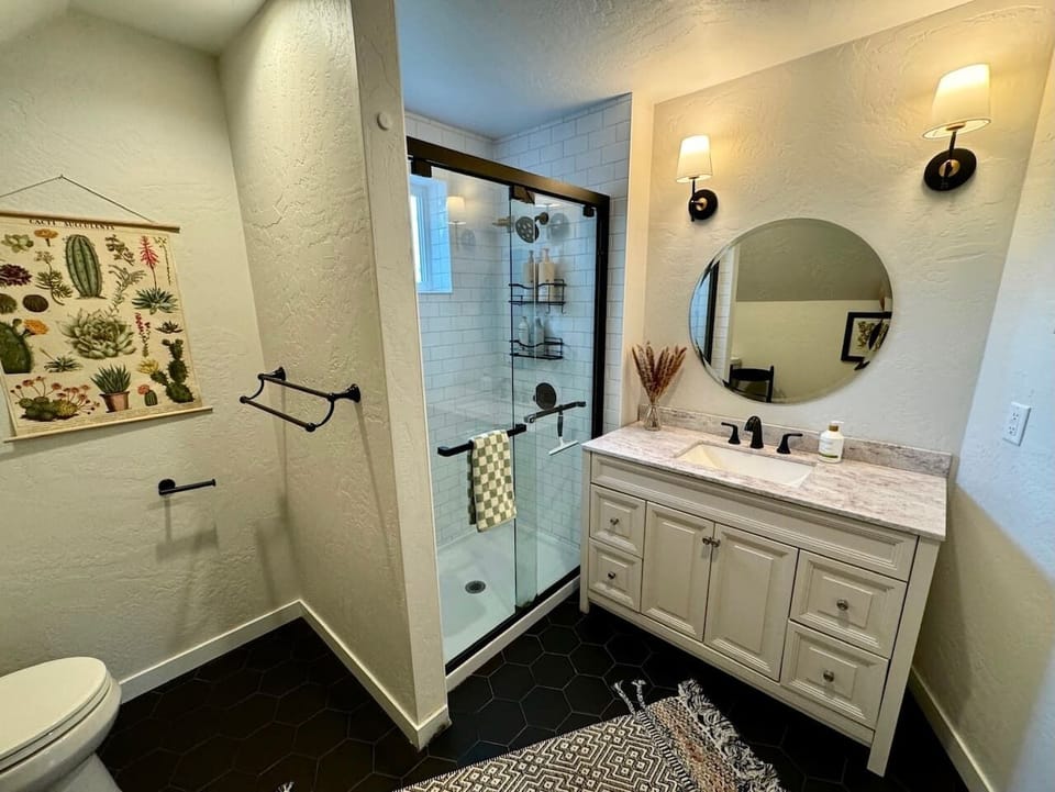 Glass walk-in shower and a vanity with counter space for two.