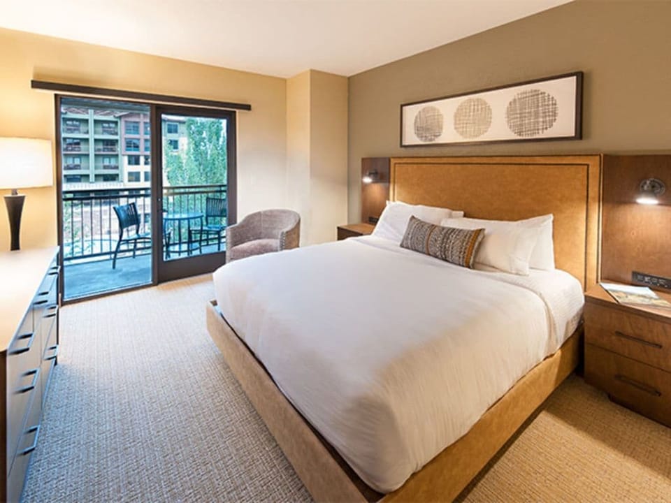 Tranquil bedroom with a king bed and large windows for natural light.