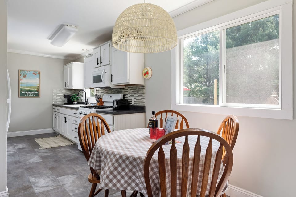 The dining table is positioned near a large window that allows natural light to fill the space.