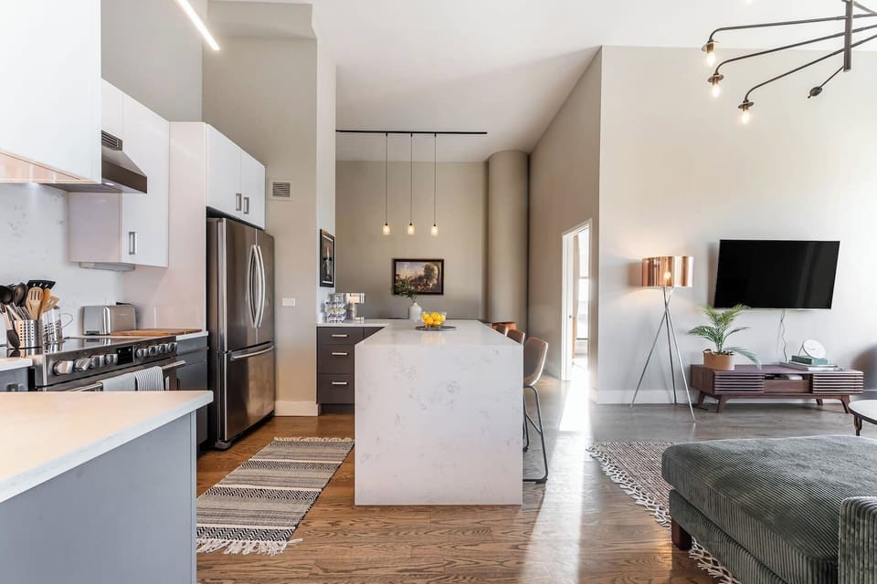 The top floor - Full kitchen, 58` smart TV, big sofa, dining area, bedroom, and private outdoor patio.