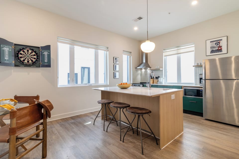 Sleek kitchen features an island with barstool seating.