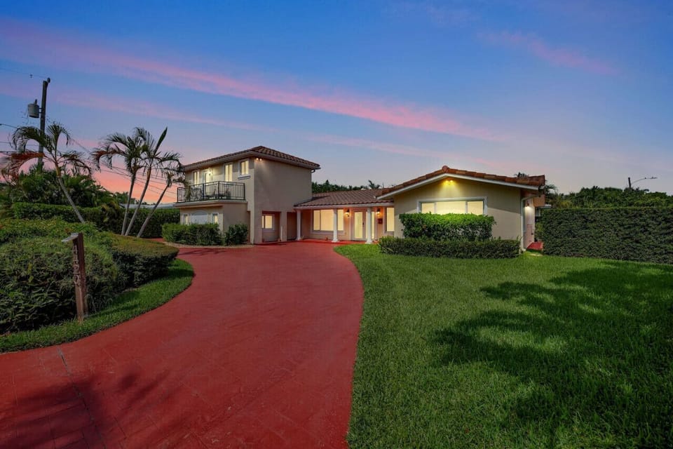 The property’s exterior is beautifully illuminated in this night shot, showcasing its design and charm with a soft, ambient glow.