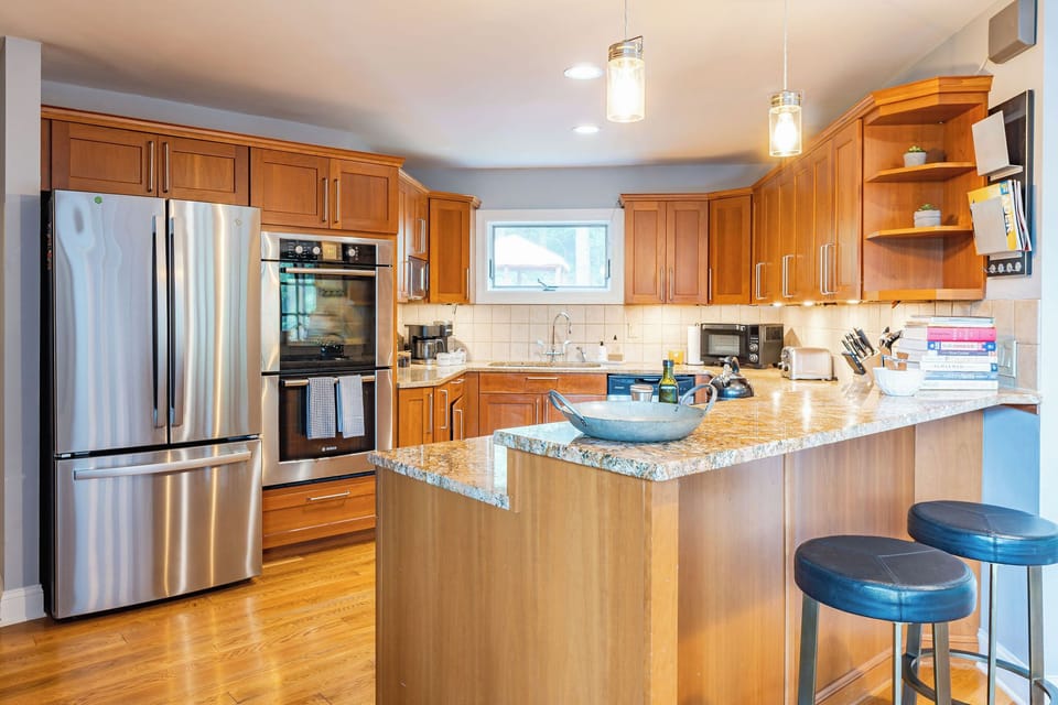 Countertop seating right by the kitchen, complete with modern stainless steel appliances. 