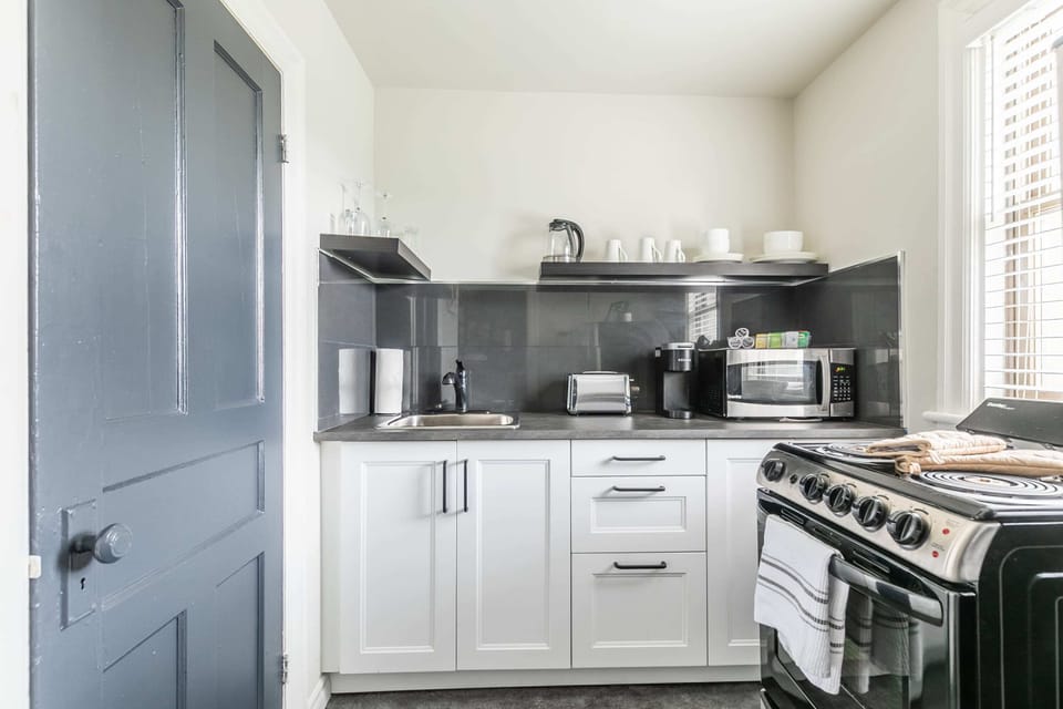 Fully Equipped Kitchen With Sleek Countertops And Essential Appliances