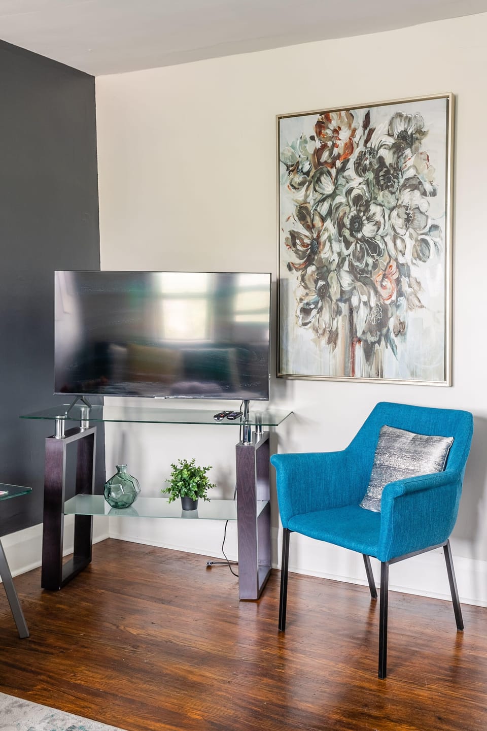 Bright Living Area With A Smart TV And A Stylish Blue Accent Chair