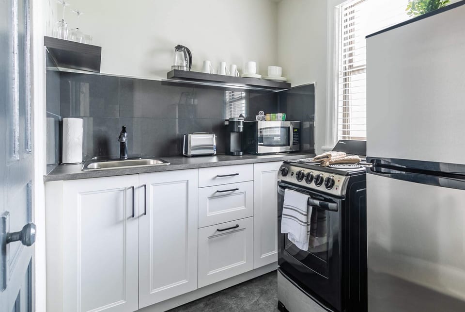 Fully Equipped Kitchen With Sleek Countertops And Modern Appliances