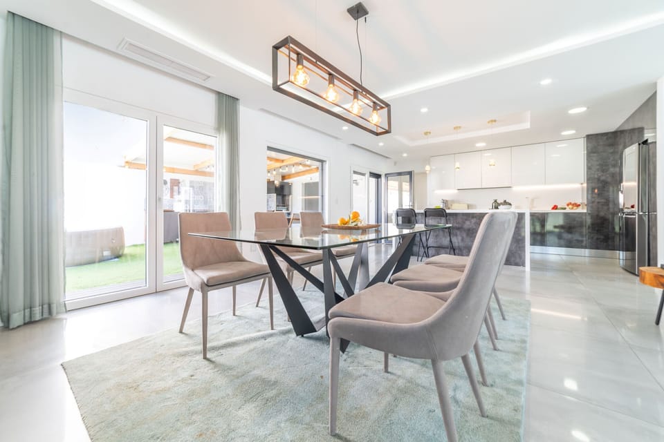 Modern open-plan dining and kitchen with glass table — Villa Alva, luxury holiday villa in Aroeira