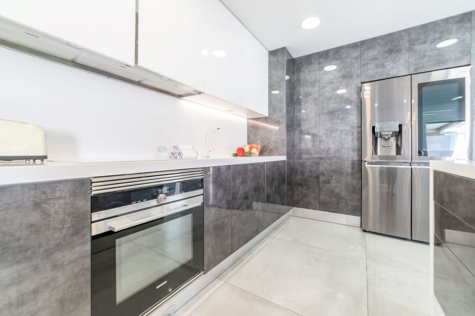 Modern kitchen with grey cabinetry and stainless steel appliances — Villa Alva, luxury holiday villa in Aroeira