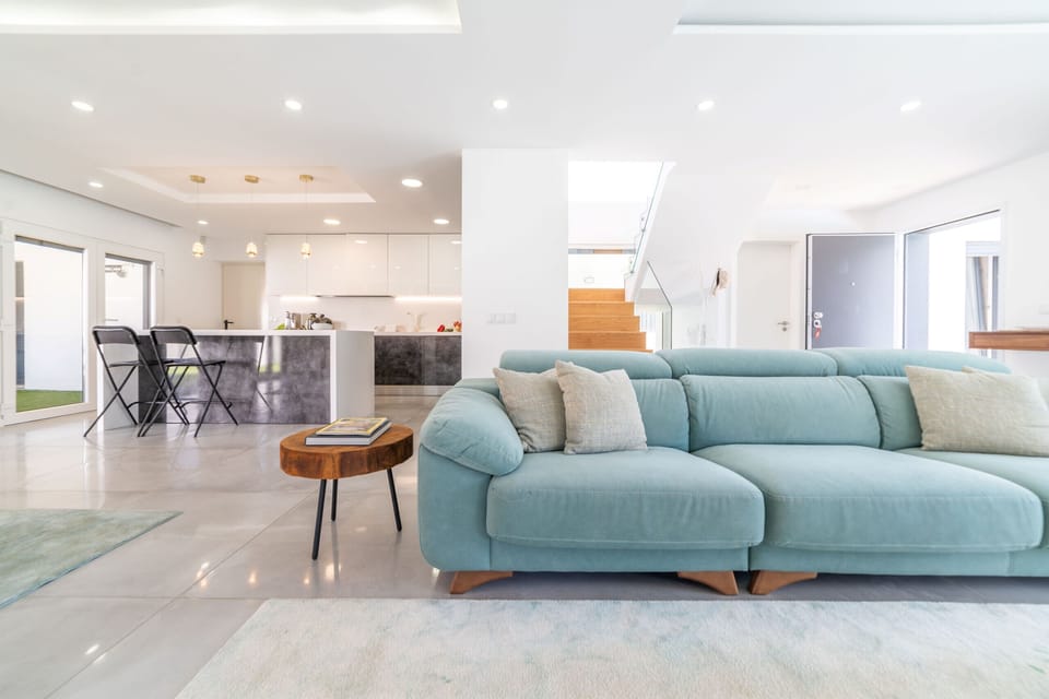 Bright open-plan living room with turquoise sofa — Villa Alva, luxury holiday villa in Aroeira