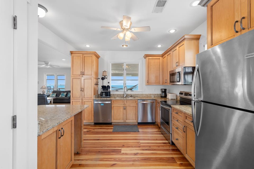 Your gourmet kitchen features granite countertops, stainless steel appliances, and warm wood cabinetry with stunning ocean views.