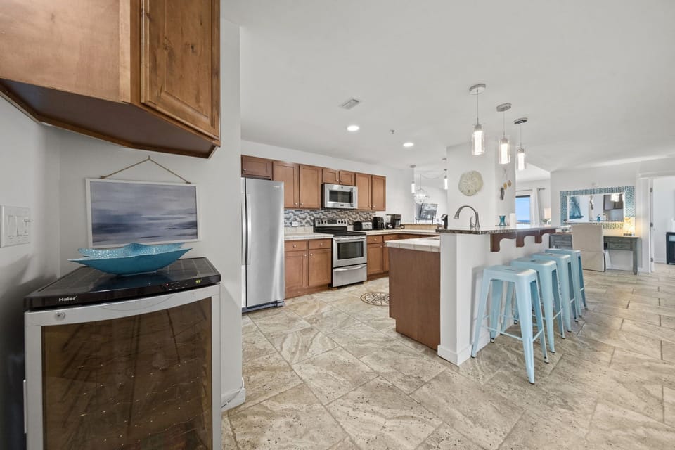 Your spacious kitchen invites you to cook together, with stainless steel appliances, a breakfast bar for morning coffee, and an open layout flowing into the living area—perfect for easy vacation living.