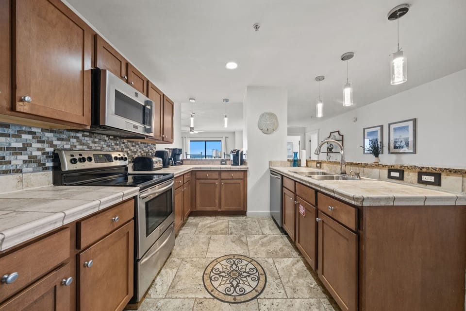 Step into your fully-equipped kitchen with warm wood cabinets, granite countertops, and modern appliances—everything you need to cook your favorite meals with a view.