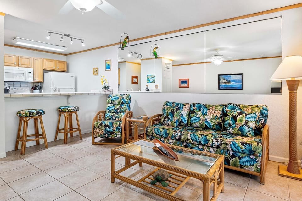 The living area offers plush seating, TV and ceiling fan.