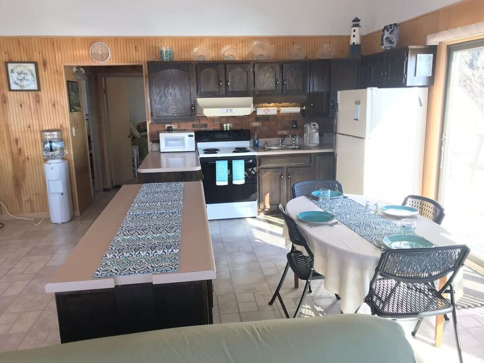 Kitchen highlights include seating for 6, a Keurig coffee machine with provided pods, a dishwasher, complimentary pure spring water dispenser, a microwave, a toaster oven, and plenty of various baking dishes, utensils, and spices.