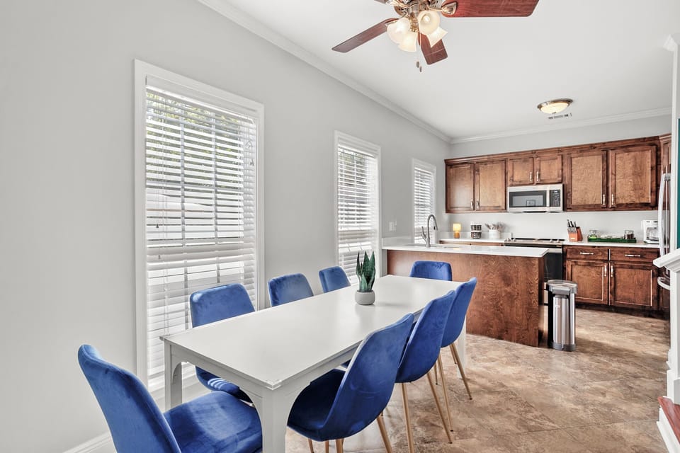 Dining Room: Gather around the chic white table with vibrant blue chairs for delightful meals!