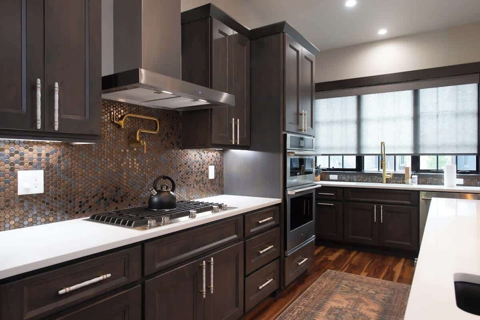- Cook in style with a sleek gas range, artisan backsplash, and built in double ovens
- Enjoy rich cabinetry and brass accents that blend function and flair
- Whether breakfast or dinner, this kitchen is fully equipped

