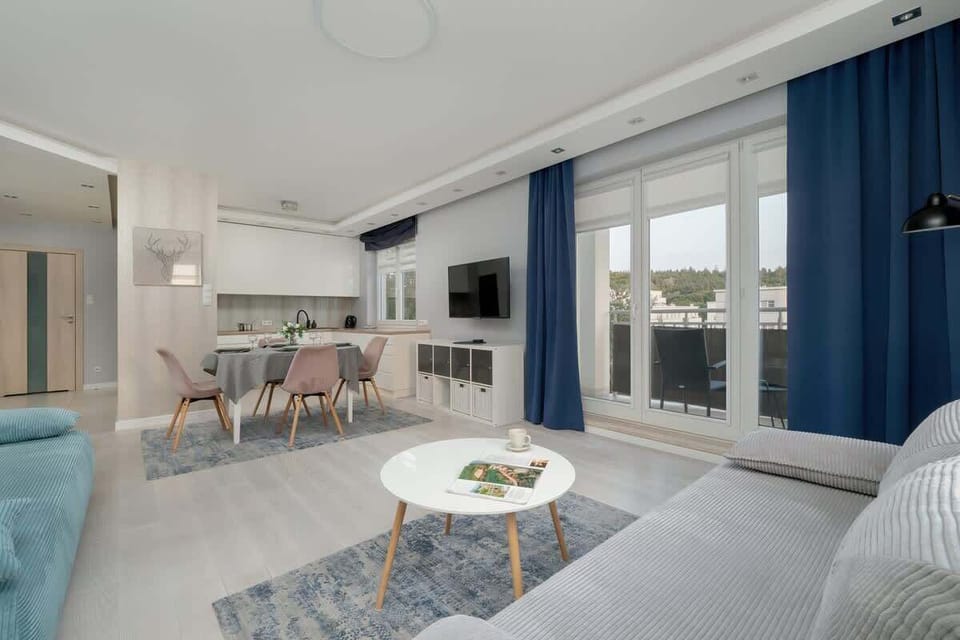 Modern living room with sofas, blue curtains, and a coffee table.