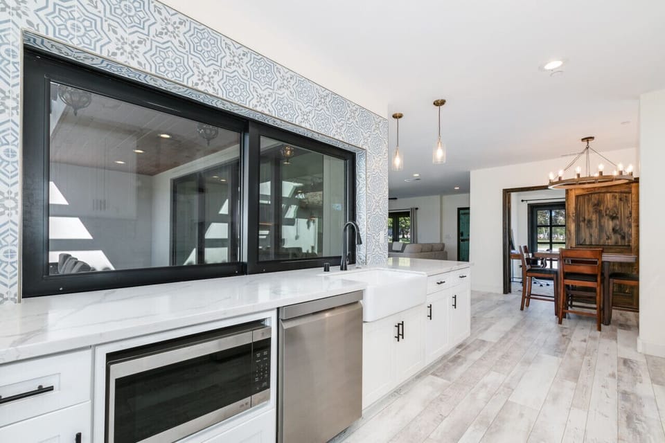 Luxurious kitchen featuring marble countertops, stainless steel appliances, and a large window for natural light.