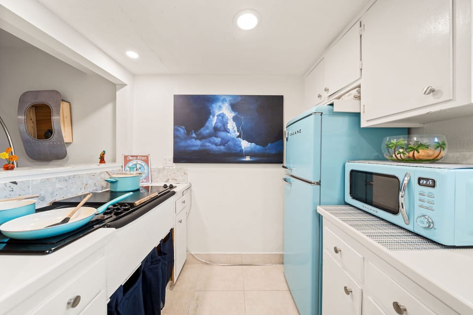 Kitchen is equipped with blue-themed appliances and equipment.