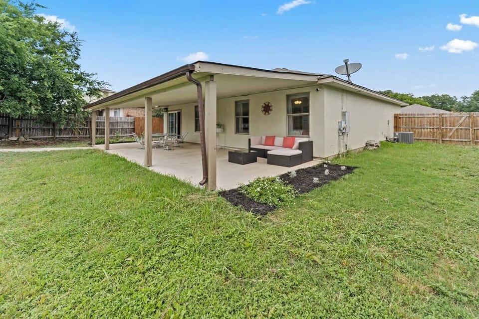 The relaxing backyard has a large covered patio with plenty of outdoor seating.