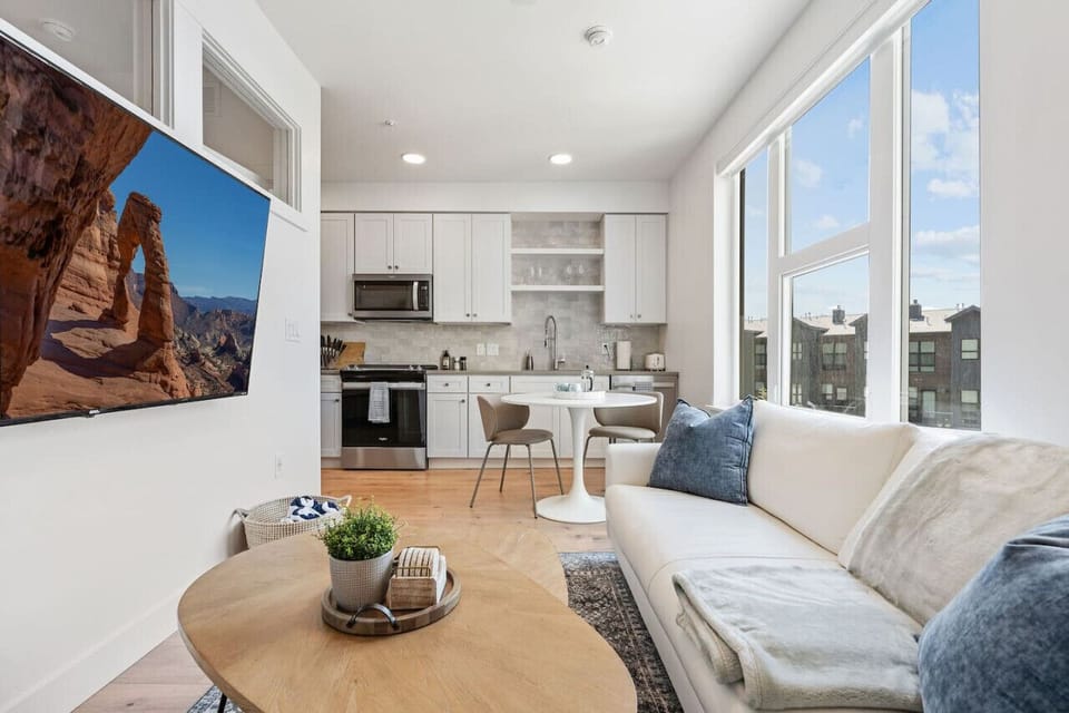 Beautifully designed living room. 65` TV, leather sofa and amazing views of mountains and city skyline.
