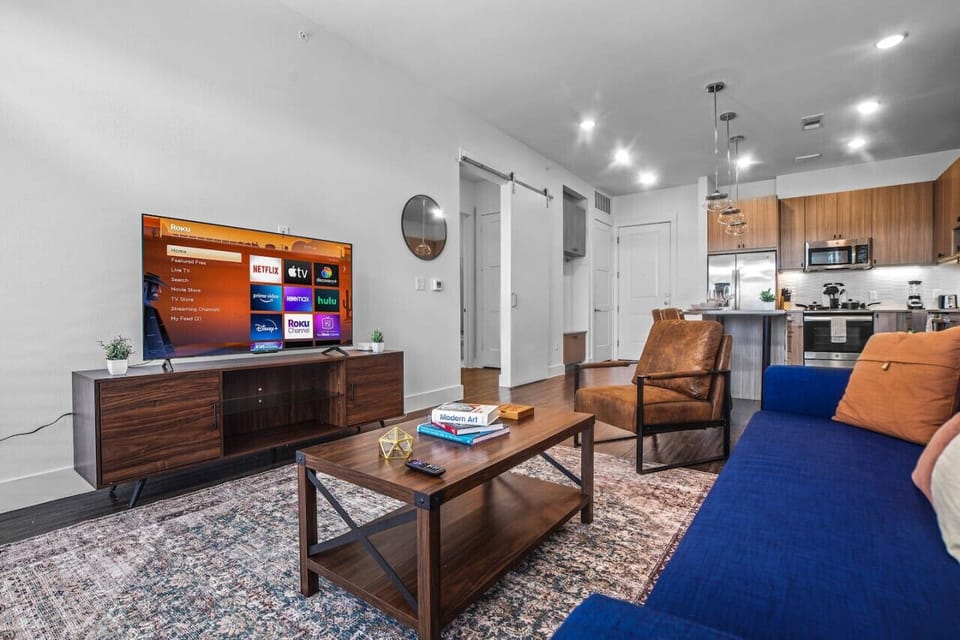 Bright and airy living room with plush seating, a large TV, and tasteful decor, creating the perfect space for relaxation and entertainment.