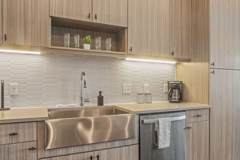 This contemporary kitchen is a chef's dream, featuring a large island, modern stainless steel appliances, and sleek cabinetry. The open layout ensures you can cook and entertain effortlessly, making it the perfect space for culinary creativity and social