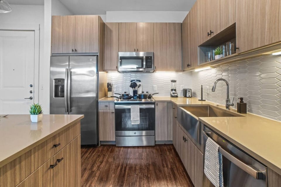 This contemporary kitchen is a chef's dream, featuring a large island, modern stainless steel appliances, and sleek cabinetry. The open layout ensures you can cook and entertain effortlessly, making it the perfect space for culinary creativity and social
