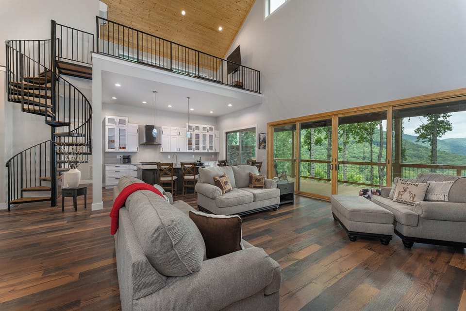 Living room with spiral staircase leading to upstairs loft area