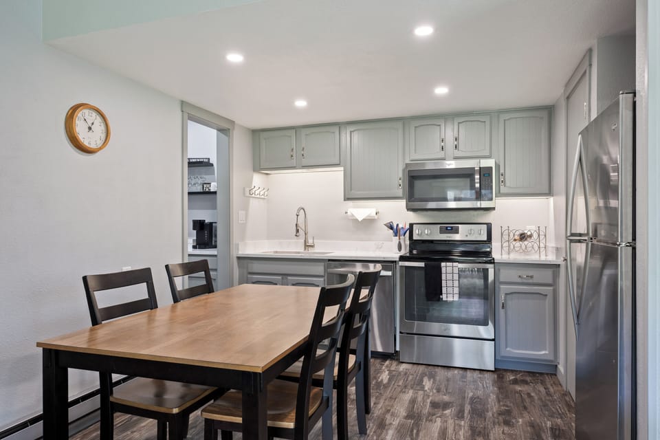 Spacious kitchen and dining area featuring modern appliances, generous counter space, and seating for shared meals in a bright, open layout.