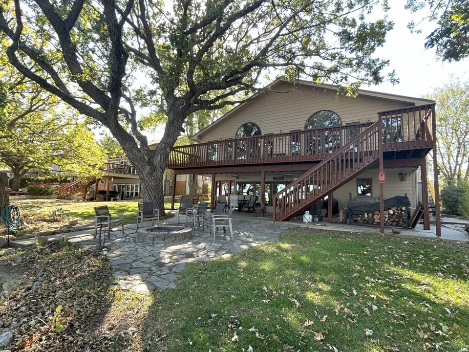 Lake/dock view of house, patio and firepit area (and massive 100+ yr old Oak!)