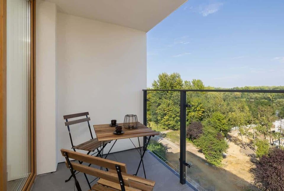 Private balcony with seating for two and panoramic views of the surrounding greenery, perfect for morning coffee or sunset watching.