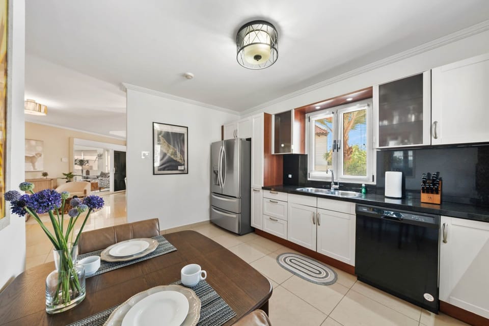 - Bright kitchen with modern stainless steel appliances and sleek black countertop - Cozy breakfast nook with a charming table, perfect for casual dining or morning coffee - Open layout flows effortlessly into the living space, ideal for entertaining