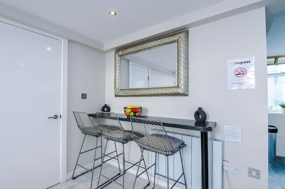 The open-plan living room and dining area benefit from a 50-inch Smart TV, a 4-seater dining table,  a 3-seater breakfast bar, plenty of space to sit down in the evenings and a double sofa bed.